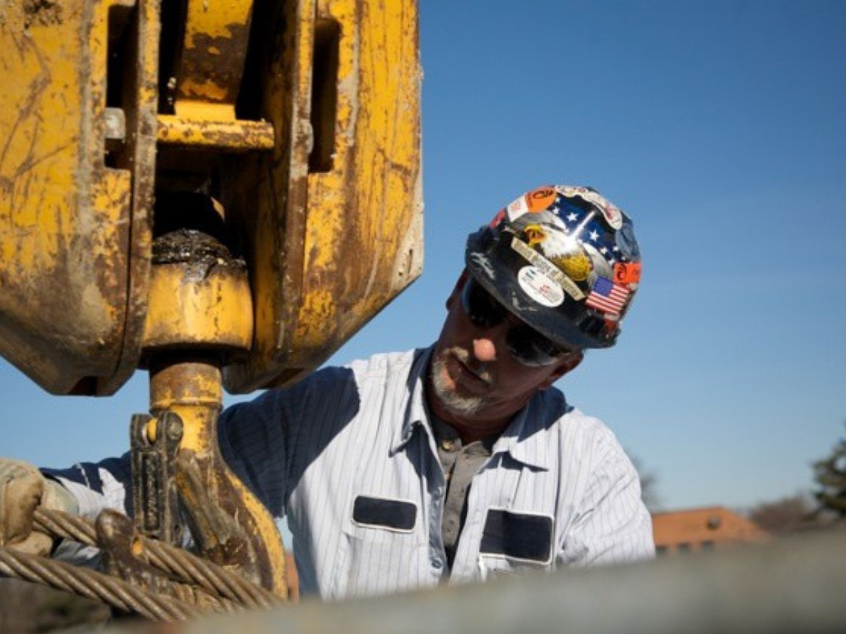 construction workers, standing around construction site smiling, crane  operatros